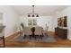 Bright dining room features hardwood floors, stylish lighting, and comfortable seating for six at 3413 Thistledown Ct, Efland, NC 27243
