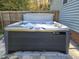 Outdoor hot tub on a brick patio with a wooden fence and a view of the surrounding trees at 3413 Thistledown Ct, Efland, NC 27243