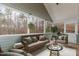 Enclosed porch with paneled walls, wood floors and views of the wooded area with virtual staging at 3413 Thistledown Ct, Efland, NC 27243