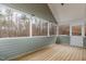 Enclosed porch with paneled walls, wood floors and views of the wooded area at 3413 Thistledown Ct, Efland, NC 27243