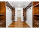 Spacious walk-in closet with hardwood floors and custom wood shelving and drawers at 3413 Thistledown Ct, Efland, NC 27243