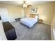 Bedroom featuring soft carpet, neutral walls, natural light, and a relaxing queen bed at 4809 Kaycee Ct, Raleigh, NC 27616