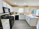 Bright kitchen with white cabinets, black appliances, gray flooring, and lots of counter space at 4809 Kaycee Ct, Raleigh, NC 27616