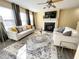 Spacious living room has a fireplace, gray curtains, light walls, and ceiling fan at 4809 Kaycee Ct, Raleigh, NC 27616