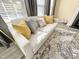Cozy sofa featuring bright yellow pillows, and a light gray wood floor at 4809 Kaycee Ct, Raleigh, NC 27616