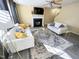 Bright living room with light walls, and gray wood-look floors, and a fireplace at 4809 Kaycee Ct, Raleigh, NC 27616