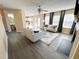 Open-concept living room showcases lots of windows, a kitchen area, and gray wood-look flooring at 4809 Kaycee Ct, Raleigh, NC 27616