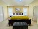 Main bedroom with tray ceilings and light walls and a gray velvet bench at 4809 Kaycee Ct, Raleigh, NC 27616