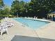 Community swimming pool featuring lounge chairs, and lush surroundings on a sunny day at 4809 Kaycee Ct, Raleigh, NC 27616