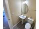 Compact powder room with pedestal sink, gray wood-look floors, and light walls at 4809 Kaycee Ct, Raleigh, NC 27616