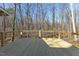 A spacious wooden back deck overlooks a serene wooded area, perfect for outdoor relaxation at 5709 Russell Rd, Durham, NC 27712