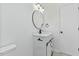 Bathroom with stylish vanity, round mirror, and black hardware provides a sleek modern look at 5709 Russell Rd, Durham, NC 27712