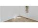 An empty room is brightened by natural light from the window with newly installed floors at 5709 Russell Rd, Durham, NC 27712