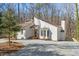 Exterior view of a modern home with a light colored gravel drive, unique architectural design, and a chimney at 5709 Russell Rd, Durham, NC 27712