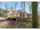 Rear exterior of the home featuring a deck, screened-in porch, and wooded surroundings at 5709 Russell Rd, Durham, NC 27712