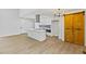 Bright kitchen with white cabinets, island cooktop, and stainless hood at 5709 Russell Rd, Durham, NC 27712