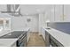Updated kitchen with island cooktop, stainless appliances, and modern lighting at 5709 Russell Rd, Durham, NC 27712