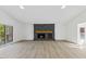Spacious living room with modern floors, stone fireplace, and sliding glass doors to the outdoor deck at 5709 Russell Rd, Durham, NC 27712