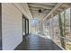 A screened-in porch with wooden floors and a ceiling fan provides a comfortable outdoor living space at 5709 Russell Rd, Durham, NC 27712
