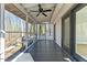 Long view of the screened porch with wooden floors, leading to a view of the trees at 5709 Russell Rd, Durham, NC 27712