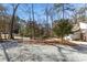 A long gravel driveway and yard with trees and light post leading to the home at 5709 Russell Rd, Durham, NC 27712