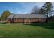Brick ranch house with a spacious lawn and mature trees at 610 Denim Dr, Erwin, NC 28339