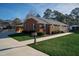 Side view of brick ranch house, showcasing driveway and landscaping at 610 Denim Dr, Erwin, NC 28339