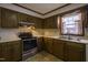 Galley kitchen with wood cabinets, stainless steel appliances, and double sink at 610 Denim Dr, Erwin, NC 28339