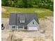 Aerial view of a gray home with a dark roof surrounded by green trees and a construction zone at 6294 River Rd, Fuquay Varina, NC 27526