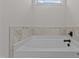 Close-up of a bright white tub with tiled walls and modern faucet at 6294 River Rd, Fuquay Varina, NC 27526