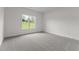Bedroom with large window showcasing the yard, and soft neutral carpet at 6294 River Rd, Fuquay Varina, NC 27526