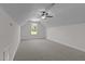 Spacious bonus room with neutral carpet, ceiling fan, and a bright window at 6294 River Rd, Fuquay Varina, NC 27526