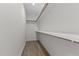 A functional walk-in closet featuring light wood floors and ample shelving at 6294 River Rd, Fuquay Varina, NC 27526