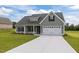 Beautiful new home showcasing a gray exterior, attached garage, and a well-maintained lawn at 6294 River Rd, Fuquay Varina, NC 27526