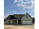 Front exterior of a beautiful gray home with a charming front porch and white trim at 6294 River Rd, Fuquay Varina, NC 27526