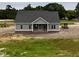 New construction featuring a covered front porch and gray siding over a brick foundation at 6294 River Rd, Fuquay Varina, NC 27526