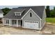 Side view of a new gray home with white trim and a large garage door at 6294 River Rd, Fuquay Varina, NC 27526
