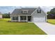 Charming gray home featuring a two-car garage, well-manicured lawn, and traditional architectural details at 6294 River Rd, Fuquay Varina, NC 27526