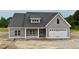 Charming gray home with a white garage door, porch, and well-manicured lawn at 6294 River Rd, Fuquay Varina, NC 27526