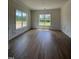 Sunlit living room with beautiful wood floors, wainscoting detail, and large windows offering scenic views at 6294 River Rd, Fuquay Varina, NC 27526