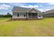 Side view of a well-maintained gray home with a screened porch and lush landscaping at 6294 River Rd, Fuquay Varina, NC 27526