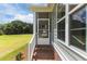 Home's screened porch entry featuring brick steps and a view of the wooded surroundings at 6294 River Rd, Fuquay Varina, NC 27526
