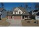 Two-story house with two-car garage, stone accents and solar panels at 897 Golden Plum Ln, Zebulon, NC 27597