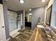 A modern bathroom with wood accents on the sink, a glass shower, and a view into the closet at 979 Natchez Trce, Fuquay Varina, NC 27526