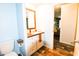 Bathroom featuring a wood-look vanity, framed mirror, and access to a living space at 979 Natchez Trce, Fuquay Varina, NC 27526