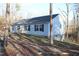 Charming single-story home featuring light siding, black shutters, and a cozy front porch nestled among the trees at 979 Natchez Trce, Fuquay Varina, NC 27526