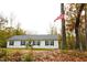 Inviting single-story home with a well-maintained lawn, surrounded by trees, and a patriotic American flag at 979 Natchez Trce, Fuquay Varina, NC 27526