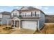 Two-story house with gray siding, brick accents, and a two-car garage at 1007 Cherry Stem Rd, Haw River, NC 27258