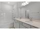 Elegant bathroom featuring double sinks, a large mirror, and a bathtub with tiled walls at 103 Central Townes Way # 297, Raleigh, NC 27603