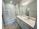 Well-lit bathroom with double sink vanity, tiled floor, and shower-tub combination at 103 Central Townes Way # 297, Raleigh, NC 27603